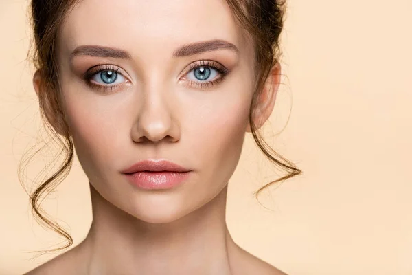 Jeune femme avec visage regardant la caméra isolée sur beige — Photo de stock