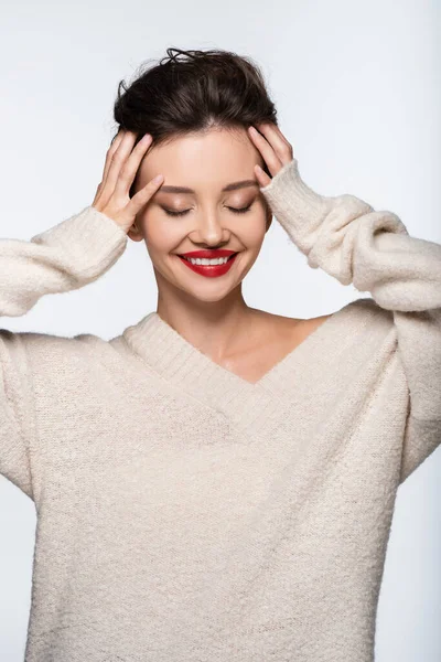 Modelo bonito em suéter sorrindo e tocando a cabeça isolada no branco — Fotografia de Stock