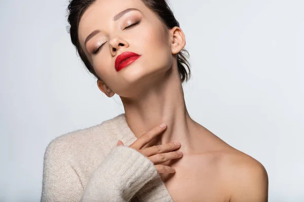 Femme à la mode en pull avec épaule nue touchant le cou isolé sur blanc — Photo de stock