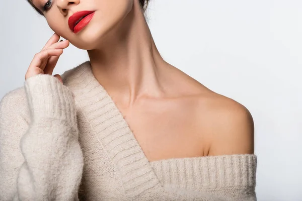 Обрезанный вид женщины с красными губами в свитере с обнаженным плечом изолирован на белом — стоковое фото