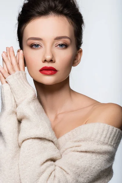 Donna alla moda in maglione caldo con spalla nuda guardando la fotocamera isolata su bianco — Foto stock