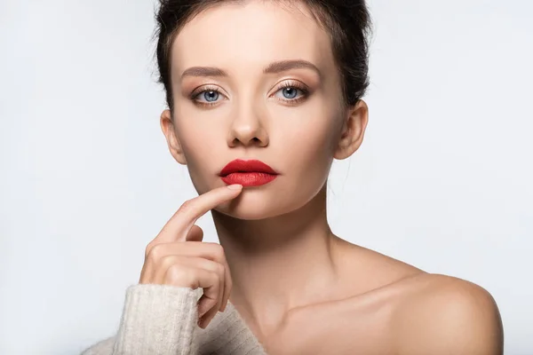 Young model with naked shoulder touching red lips isolated on white — Stock Photo