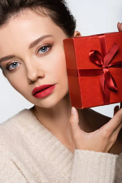 Mujer elegante en suéter con caja de regalo roja aislada en blanco - foto de stock