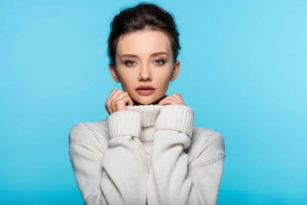 Young woman in sweater looking at camera isolated on blue — Stock Photo