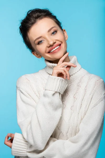 Smiling woman in knitted sweater looking at camera isolated on blue — Stock Photo