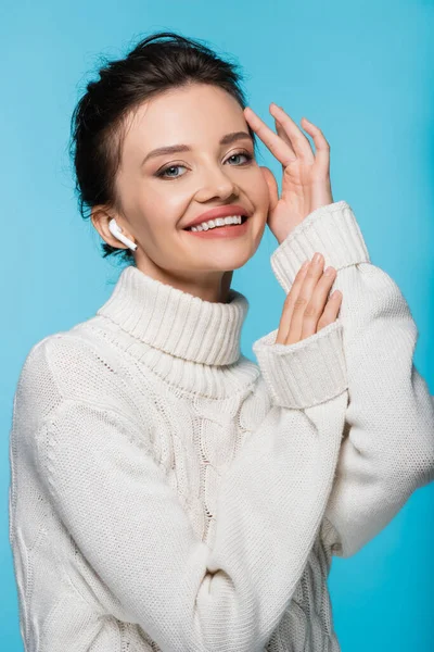 Mulher positiva em suéter e fone de ouvido posando isolado em azul — Fotografia de Stock