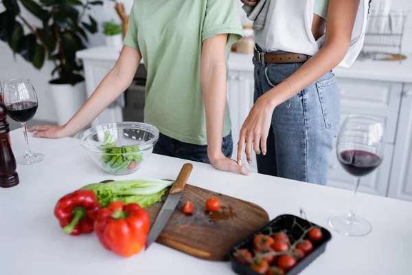 Recortado vista de jóvenes del mismo sexo pareja cocina en cocina - foto de stock