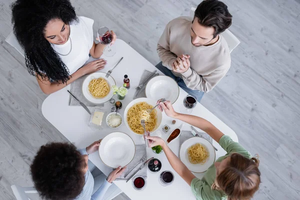 Vue du dessus d'amis multiethniques déjeunant ensemble — Photo de stock