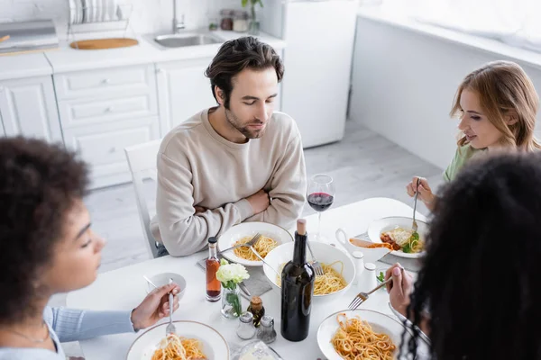 Aus der Vogelperspektive: Mann isst mit multiethnischen Frauen zu Mittag — Stockfoto