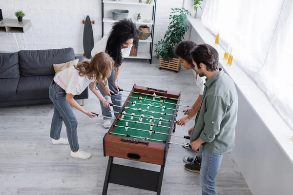 Alto ángulo vista de feliz interracial amigos jugando futbolín - foto de stock