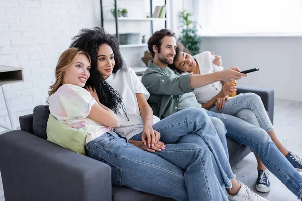 Alegre lésbicas e satisfeito heterossexual casais assistindo filme no sofá — Fotografia de Stock