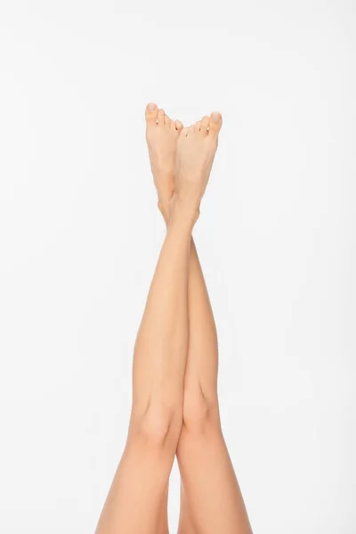 Частковий вигляд підходять жіночі ноги з гладкою шкірою ізольовані на білому — стокове фото