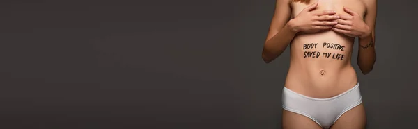 Cropped view of woman with body positive saved my life inscription on belly isolated on dark grey, banner — Stock Photo