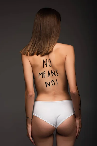 Young woman in panties, with no means no inscription on back isolated on dark grey — Stock Photo