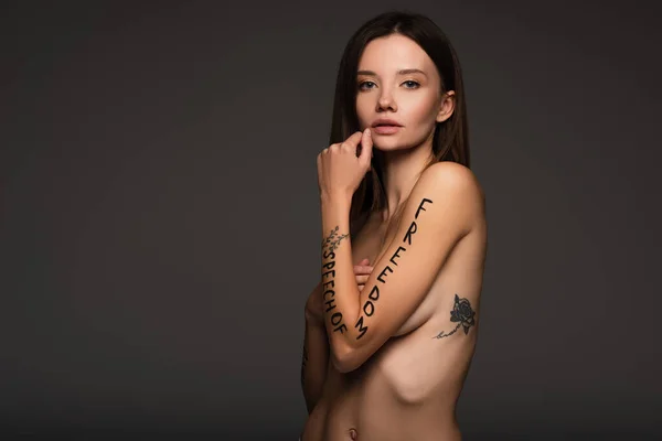 Nackte und tätowierte Frau mit Redefreiheit Phrase auf dem Arm isoliert auf dunkelgrau geschrieben — Stockfoto