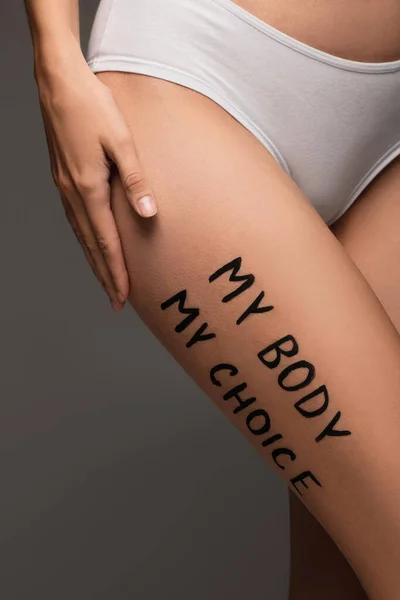 Vista parcial de la mujer en bragas, con mi cuerpo mi elección letras en la cadera aislado en gris oscuro - foto de stock