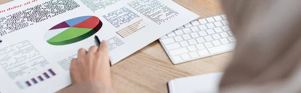 Visión parcial de la mujer borrosa con pluma que trabaja con analítica cerca del teclado, banner — Stock Photo