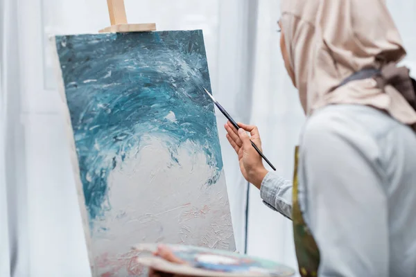 Blurred muslim woman drawing picture at home — Stock Photo