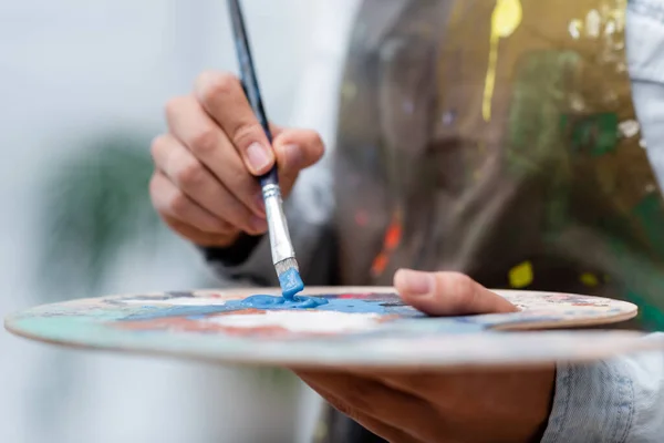 Ausgeschnittene Ansicht einer verschwommenen Frau mit Palette und Pinsel — Stockfoto