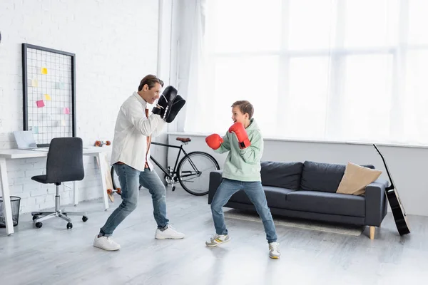 Père et fils dans la formation de gants de boxe dans le salon — Photo de stock