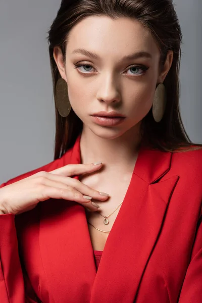 Stylische Frau im roten Blazer blickt vereinzelt in die Kamera — Stockfoto