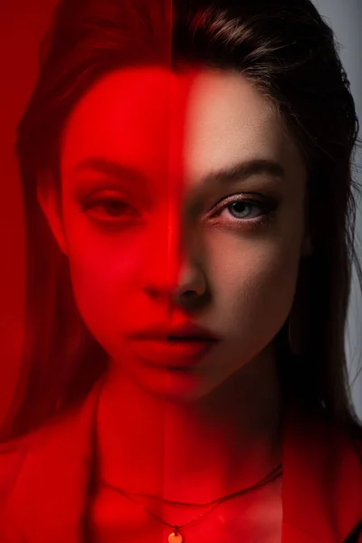 Close up of young model looking at camera through red glass — Stock Photo