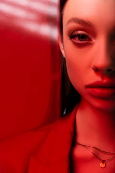Cropped view of young model looking at camera through red glass — Stock Photo