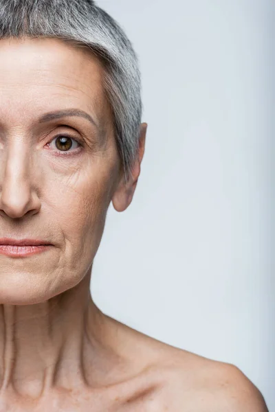 Vista parziale della donna di mezza età che guarda la fotocamera isolata sul grigio — Foto stock