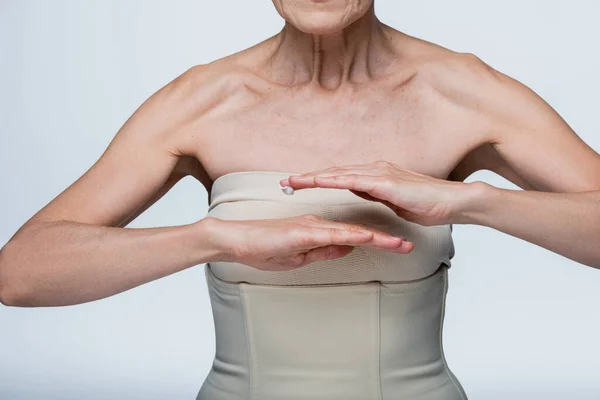 Cropped view of middle aged woman applying cream gel on hand isolated on grey — Stock Photo
