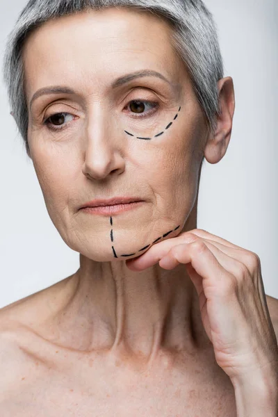 Mature woman with wrinkles and marked lines on face isolated on grey — Stock Photo