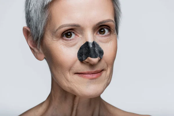 Gros plan de heureuse femme d'âge moyen avec tache noire sur le nez isolé sur gris — Photo de stock