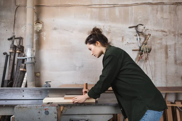 Вид сбоку деревообработчика на столярном станке в мастерской — стоковое фото