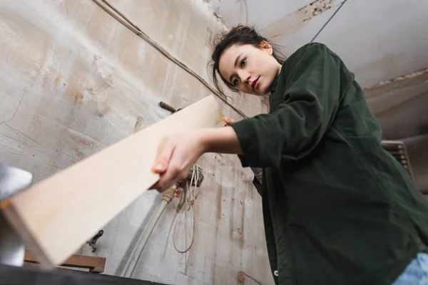 Tiefansicht des Tischlers, der Holzplanken in der Werkstatt überprüft — Stockfoto