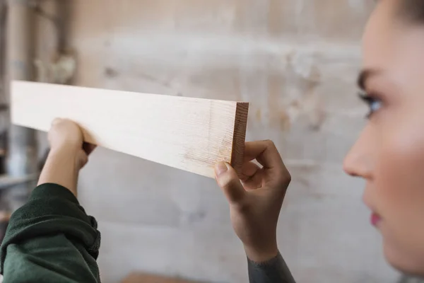 Дизайнер размытой мебели держит деревянную доску в мастерской — стоковое фото