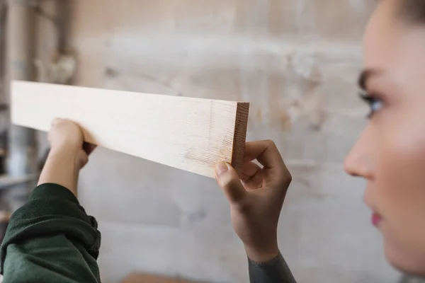 Blurred furniture designer holding wooden plank in workshop — Stock Photo