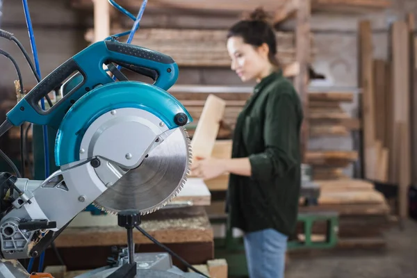 Mitra sega vicino falegname offuscata in officina — Foto stock