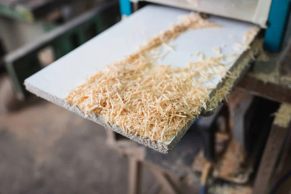 Aserrín de madera cerca de cepilladora de espesor en taller - foto de stock