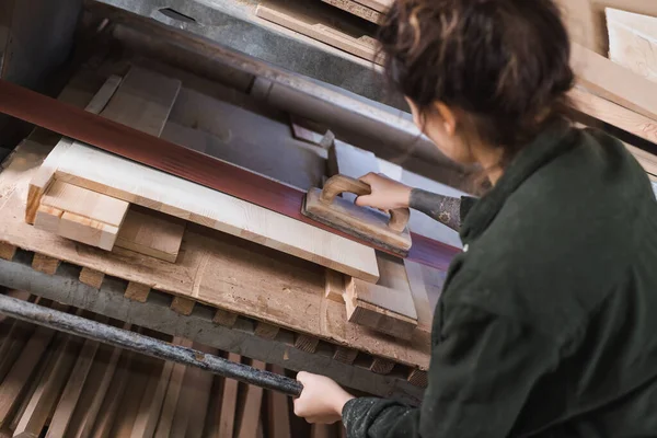 Високий кут зору татуйованих меблів дизайнер полірування дерев'яної дошки в майстерні — стокове фото
