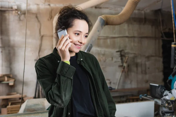 Allegro designer di mobili che parla sul cellulare in officina — Foto stock