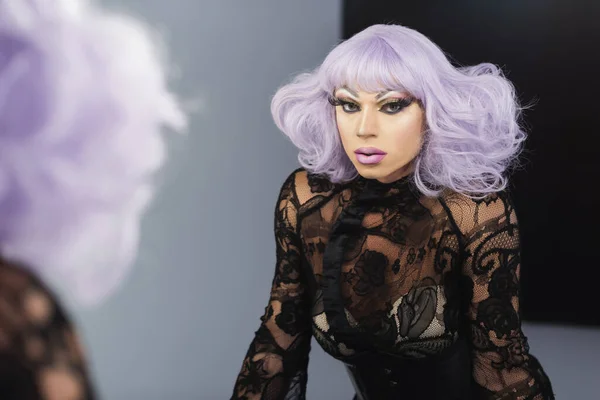 Mirror reflection of drag queen in purple wig and black lace clothing — Stock Photo