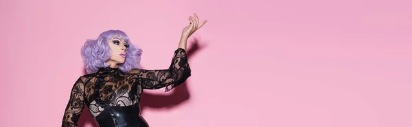 Drag queen glamour in parrucca viola punta con il dito sul rosa, banner — Foto stock