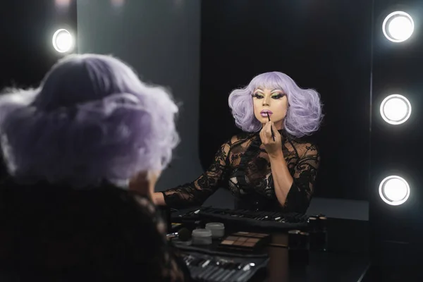 Glamour drag queen in purple wig applying lips contour with cosmetic pencil — Stock Photo