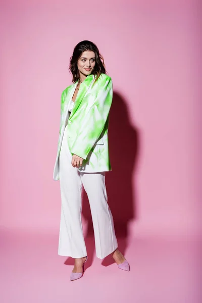 Full length of smiling woman in stylish outfit posing on pink — Stock Photo