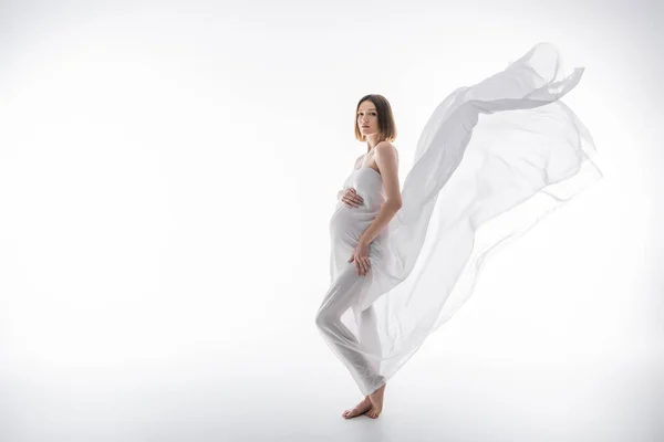Comprimento total de mulher grávida morena posando com pano no fundo cinza — Fotografia de Stock
