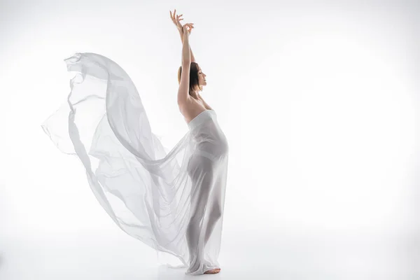 Side view of pregnant woman posing with fabric on grey background — Stock Photo