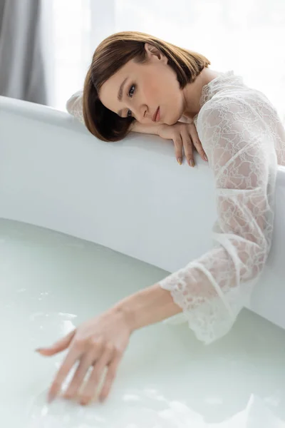 Красивая брюнетка, прикасающаяся к размытой женщине в ванной. — стоковое фото