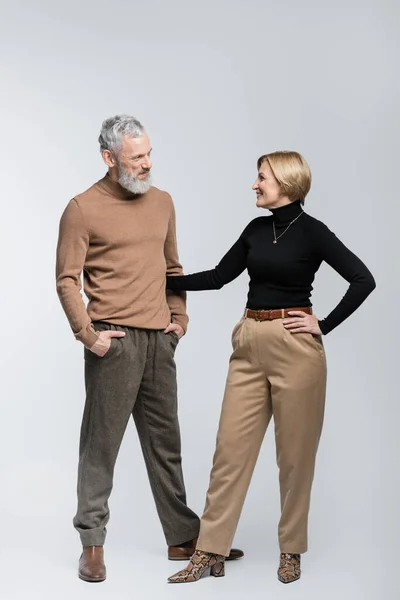 Mujer con estilo positivo abrazando marido sobre fondo gris - foto de stock