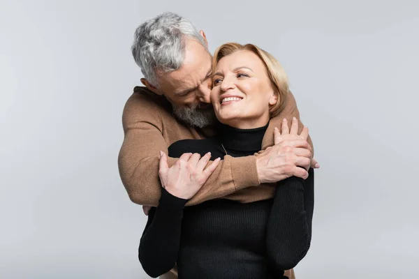 Homme aux cheveux gris embrasser et étreindre femme isolé sur gris — Photo de stock