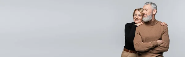 Femme d'âge moyen étreignant mari barbu isolé sur gris, bannière — Photo de stock