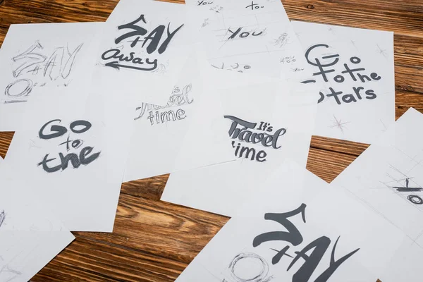 High angle view of papers with different fonts on wooden desk — Stock Photo